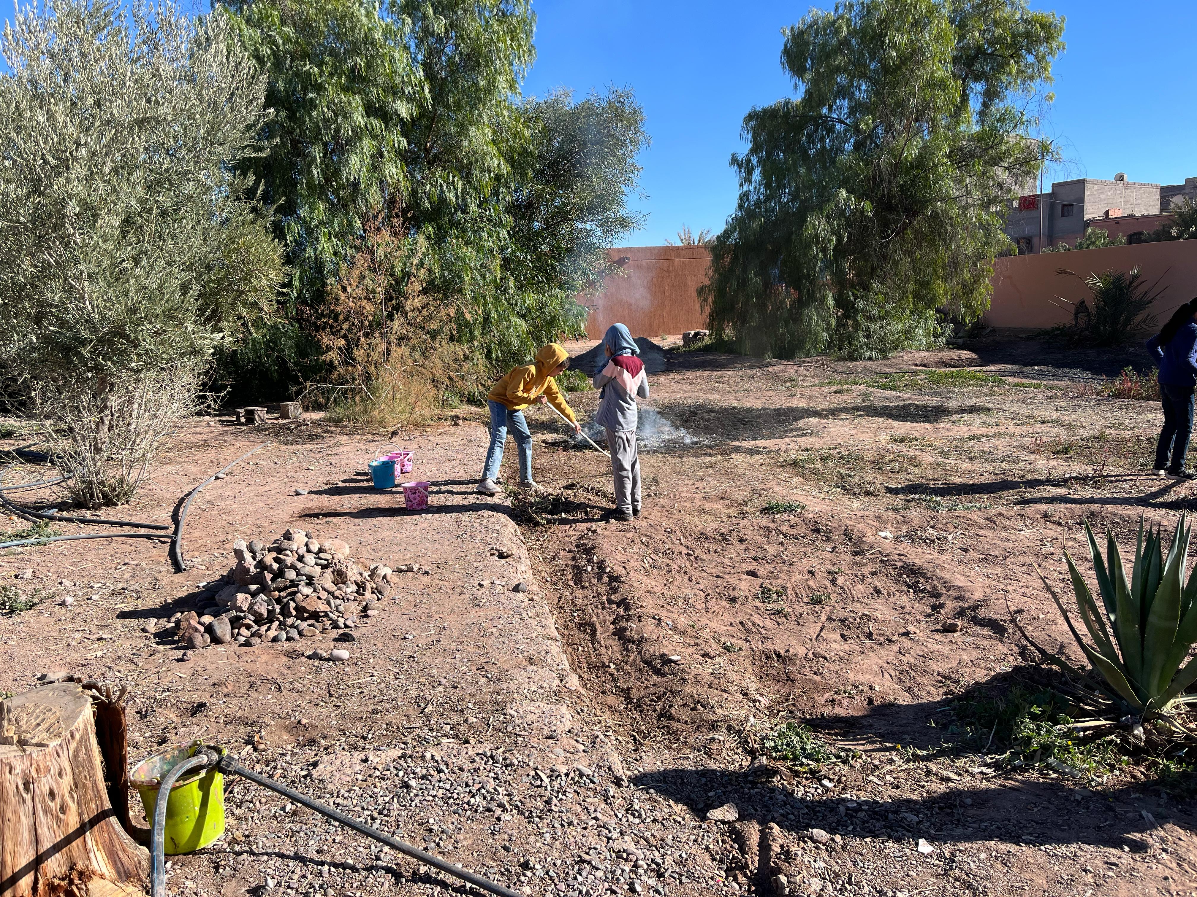 Kids working in the kitchen garden of Asmaa school